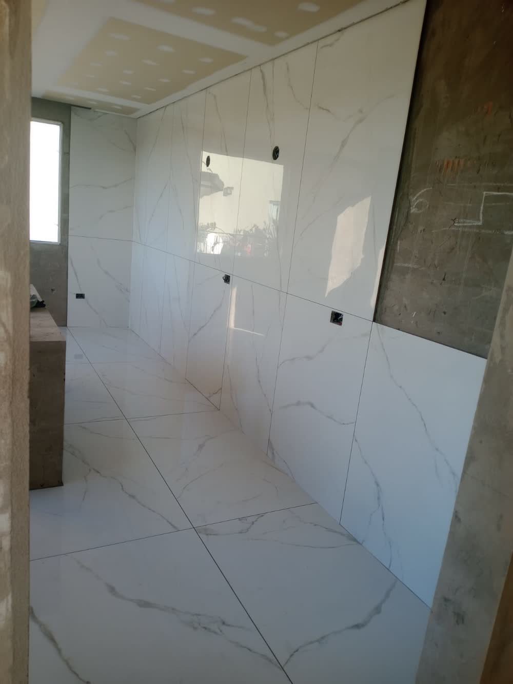 Porcelanato símil mármol colocado en piso y pared