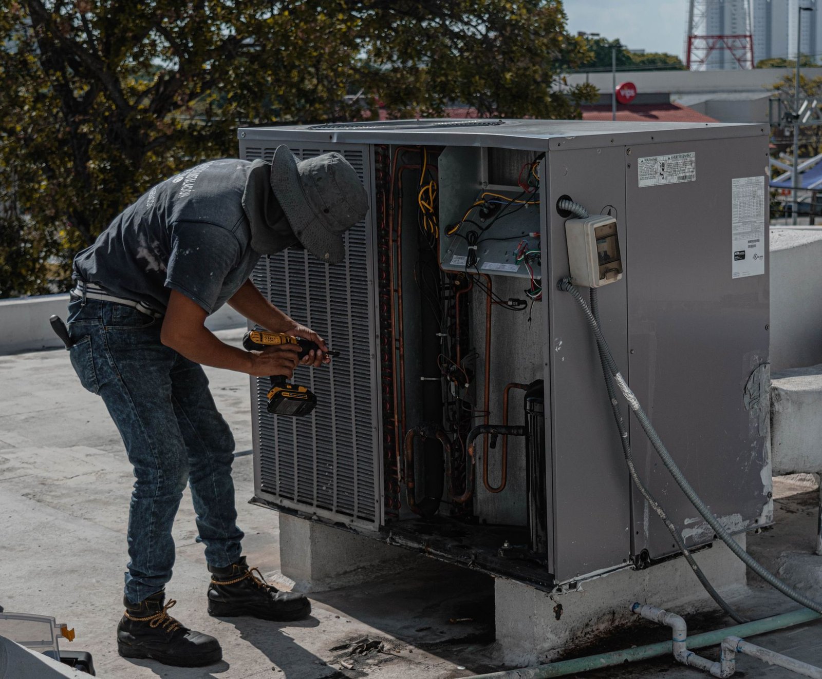 Técnico reparando un equipo de aire acondicionado en una terraza