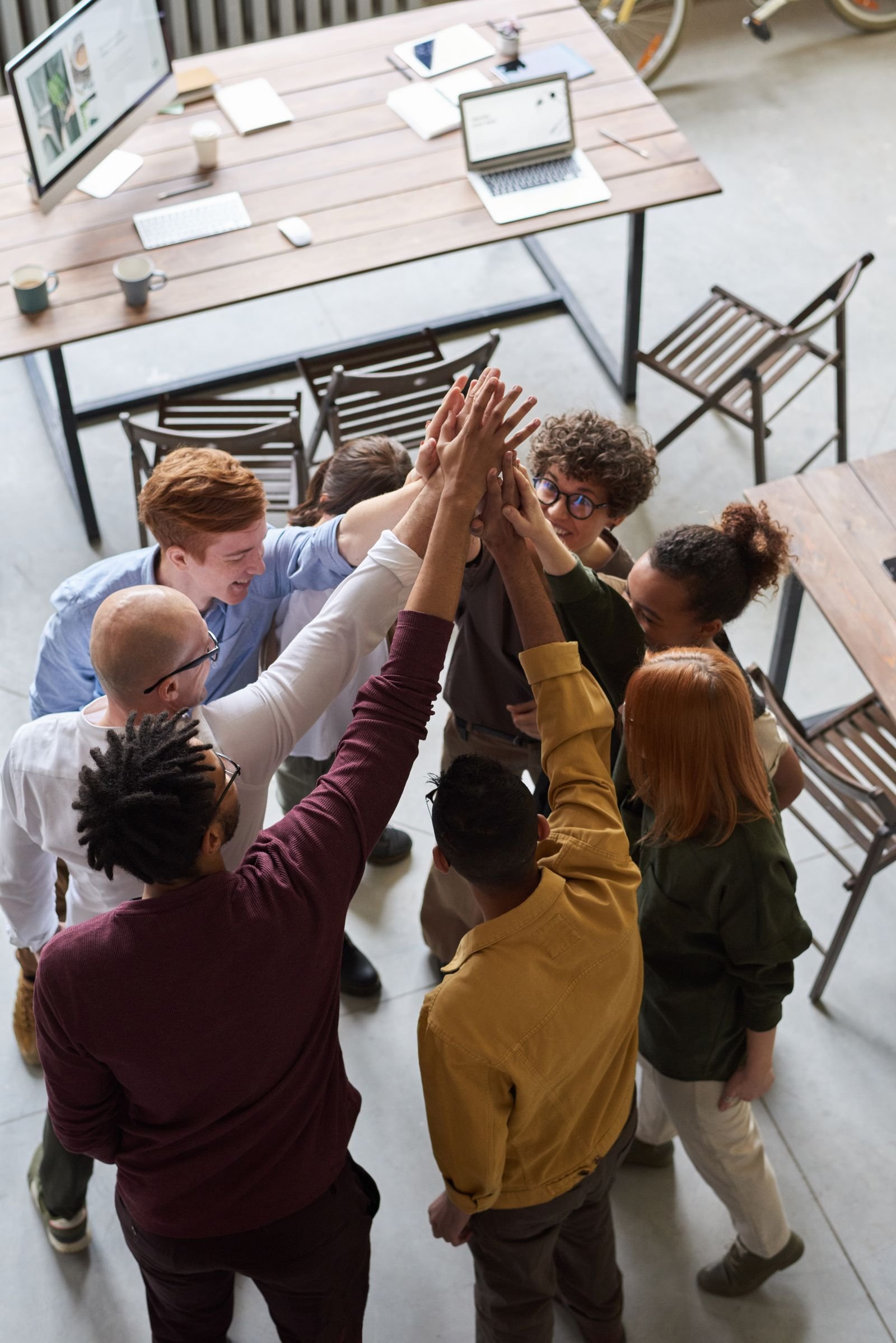 Equipo reunido en un gesto de apoyo y trabajo conjunto