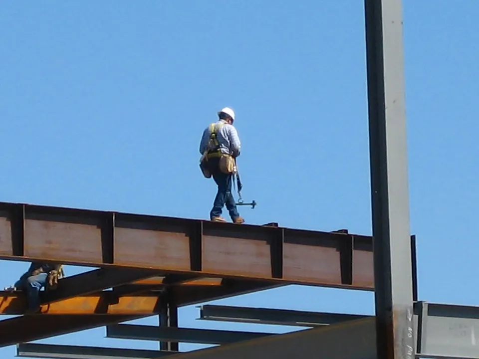 Trabajador con casco sobre una estructura metálica