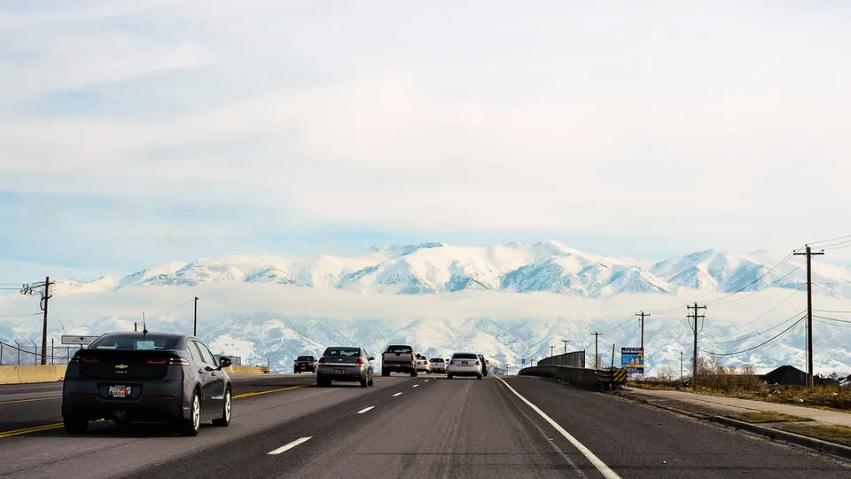 Autos en una ruta con montañas de fondo