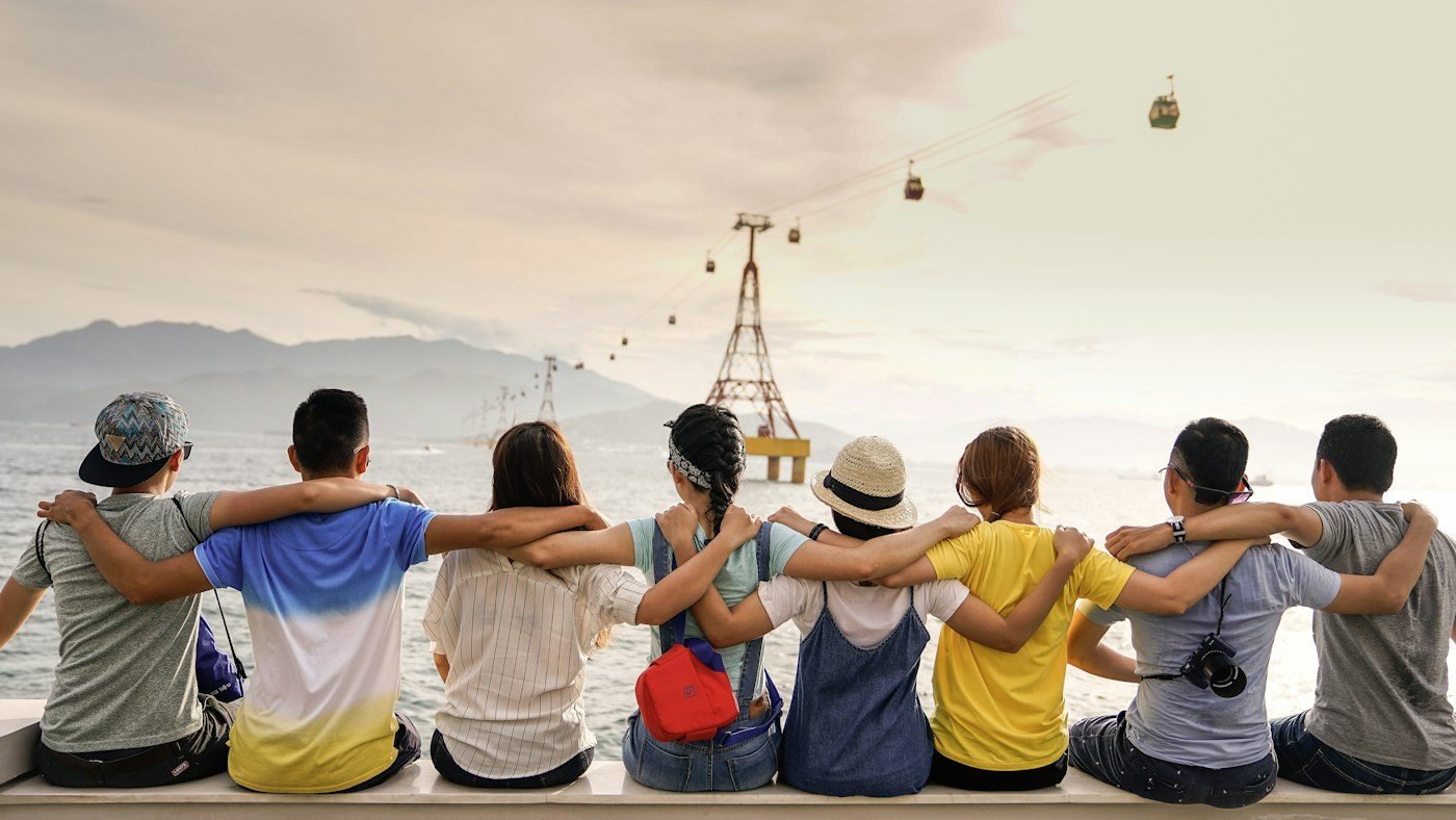 Grupo de amigos sentados juntos mirando el paisaje