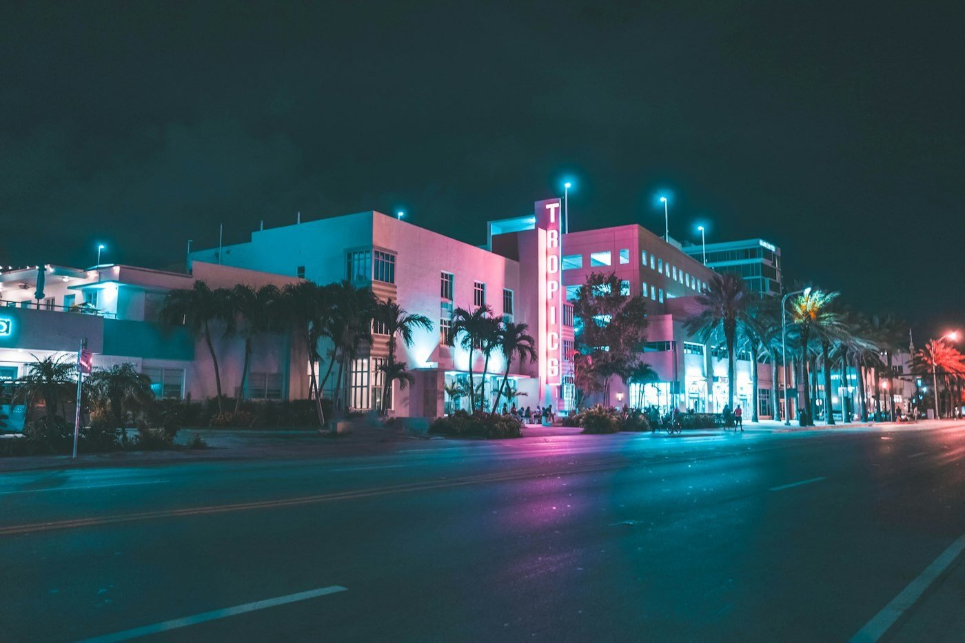 Calle de Miami Beach de noche, con palmeras y neones